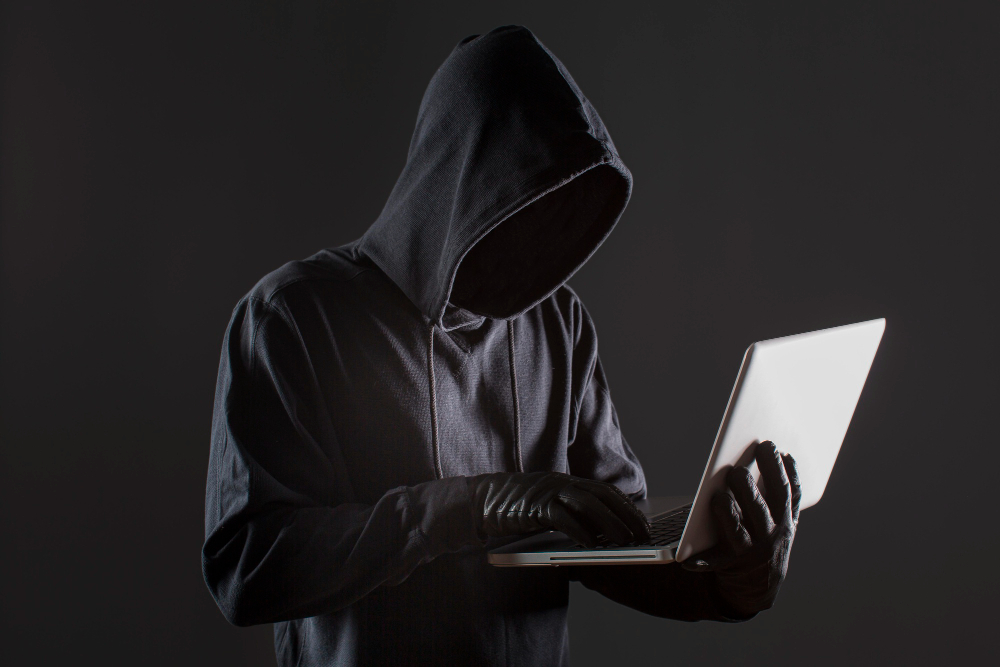 side-view-male-hacker-with-gloves-laptop